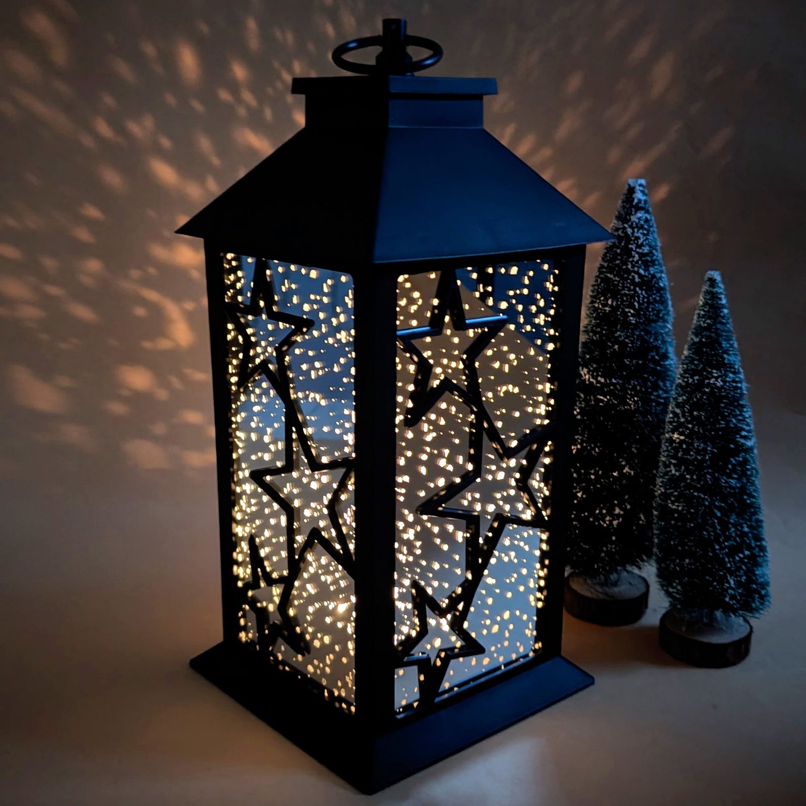 Large Black Lantern with Star Cutouts Casting Shadow Patterns — Christmas Lantern Lights