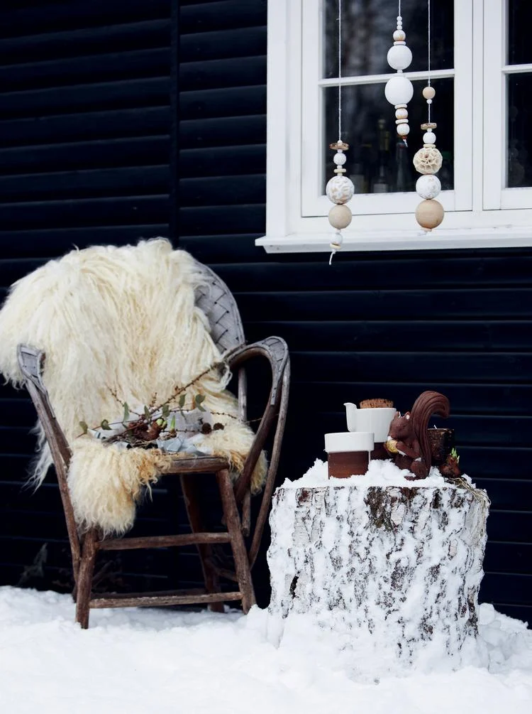 Snowy Garden Chair with Sheepskin Throw and Tree Stump Table — Winter Porch Decor