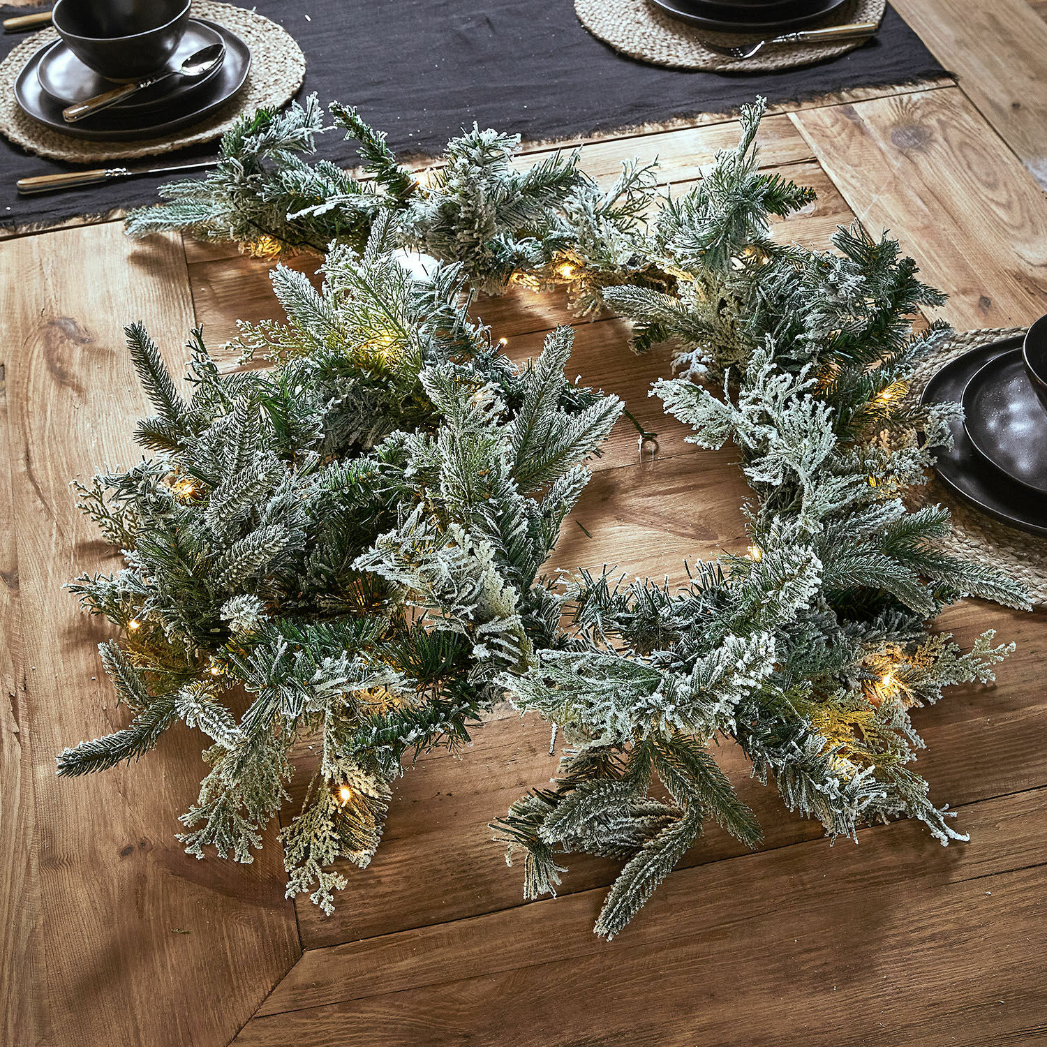 Frosted Pine Garland with LED Lights on a Rustic Wooden Table — Christmas Garland