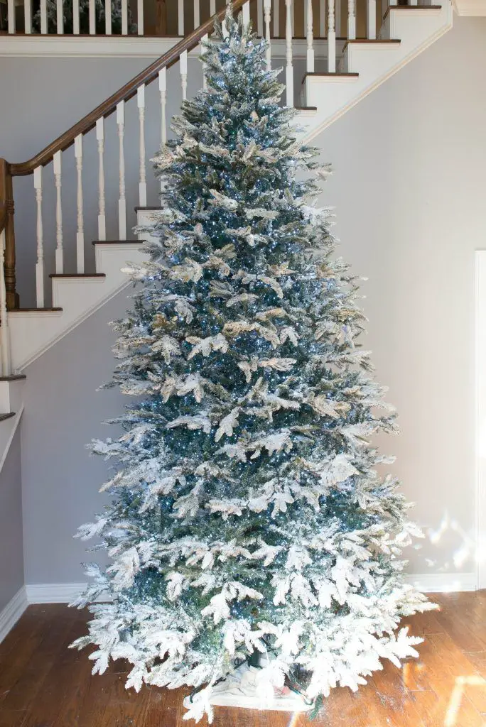Tall Flocked Christmas Tree Centered in a Blue-Hued Living Room Tall Flocked Christmas Tree Centered in a Blue-Hued Living Room — Flocked Christmas Tree Decor