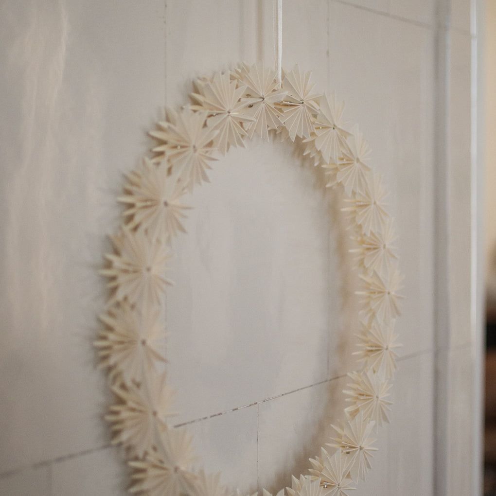 Off-White Paper Snowflake Wreath on Neutral Wall — Paper Snowflakes