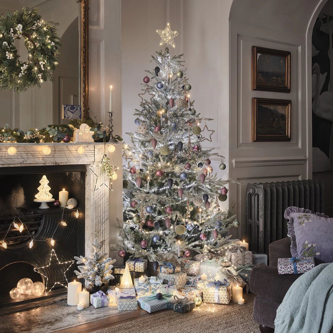 Star Topper on a Flocked Christmas Tree in a Cozy Living Room Star Topper on a Flocked Christmas Tree in a Cozy Living Room — Christmas Tree Topper