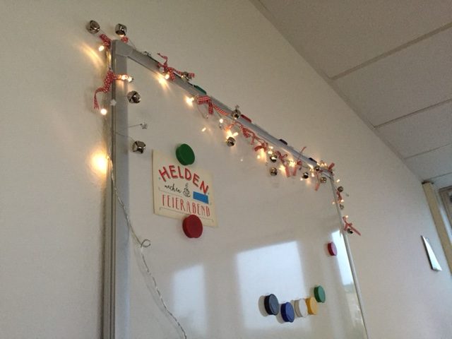 Festive Fairy Lights and Bells Adorning an Office Whiteboard Festive Fairy Lights and Bells Adorning an Office Whiteboard — Christmas Office Decor Ideas