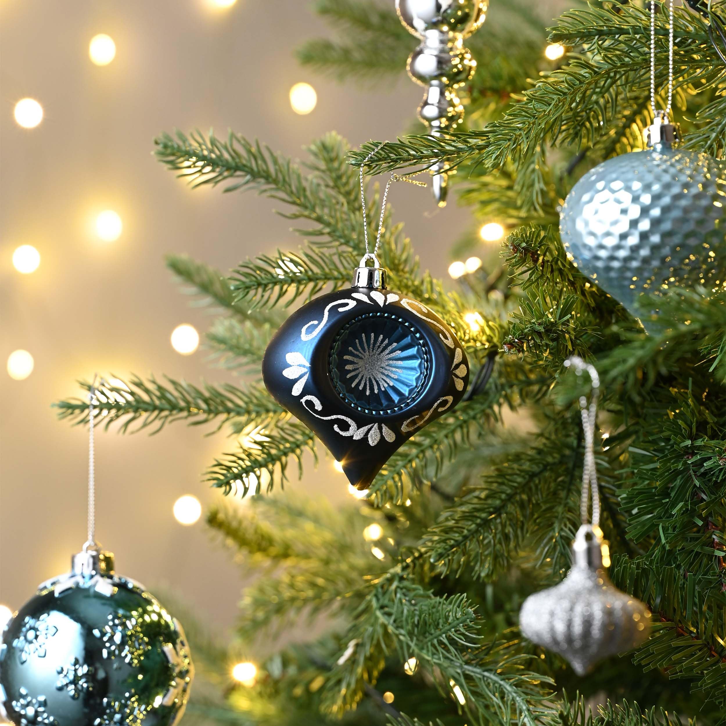 Close-Up Detail Of Ornaments On Branches Blue and Silver Ornaments on a Twinkling Christmas Tree — Blue and Silver Christmas 