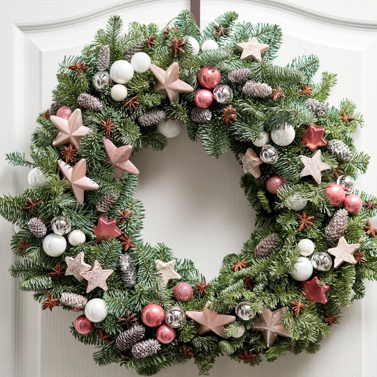 Large Lush Wreath with White and Pink Baubles on a White Door — Christmas Wreath