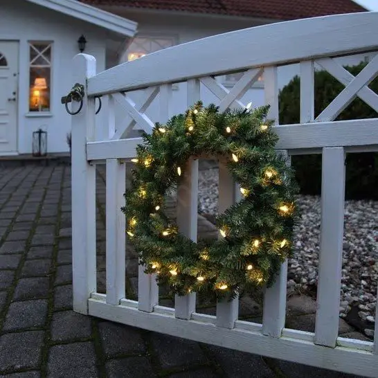 Artificial Evergreen Wreath with Warm LED Lights on a Wooden Gate — Christmas Wreath