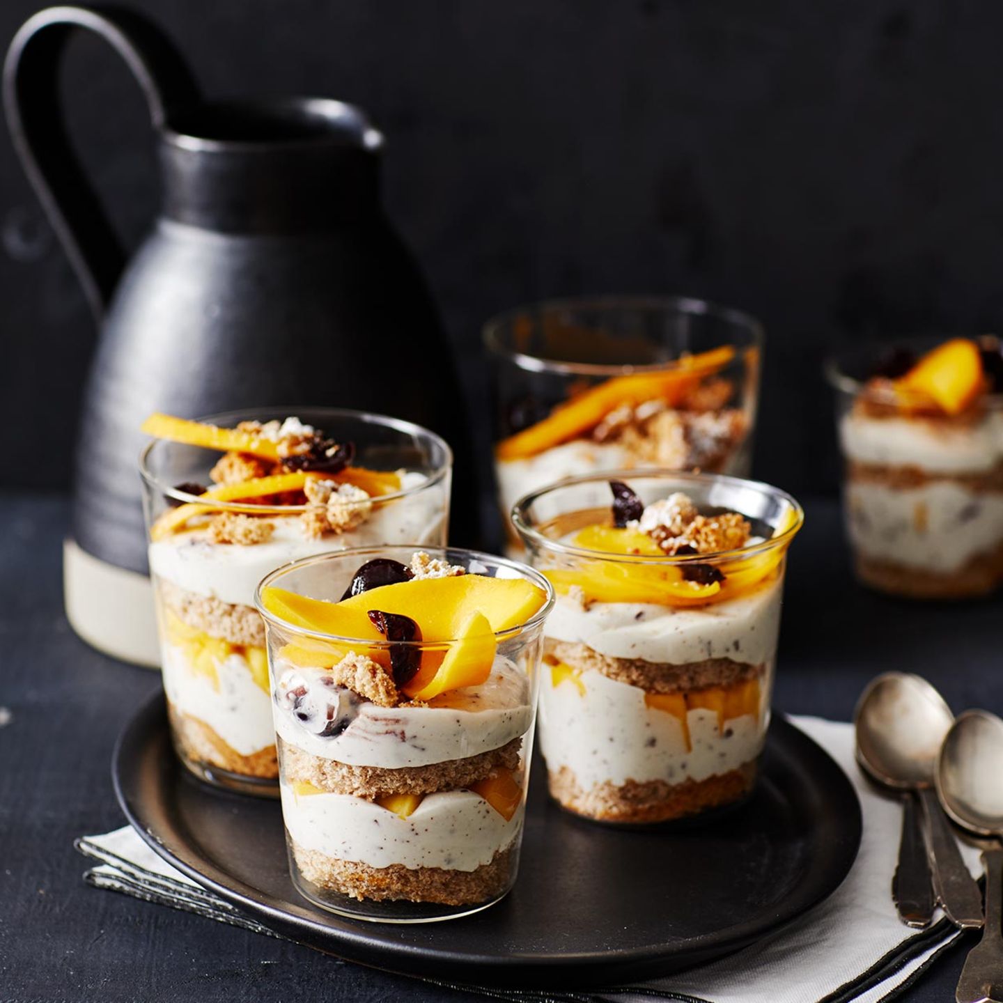 Sophisticated Layered Desserts on a Dark Ceramic Platter — New Years Eve Dessert Table