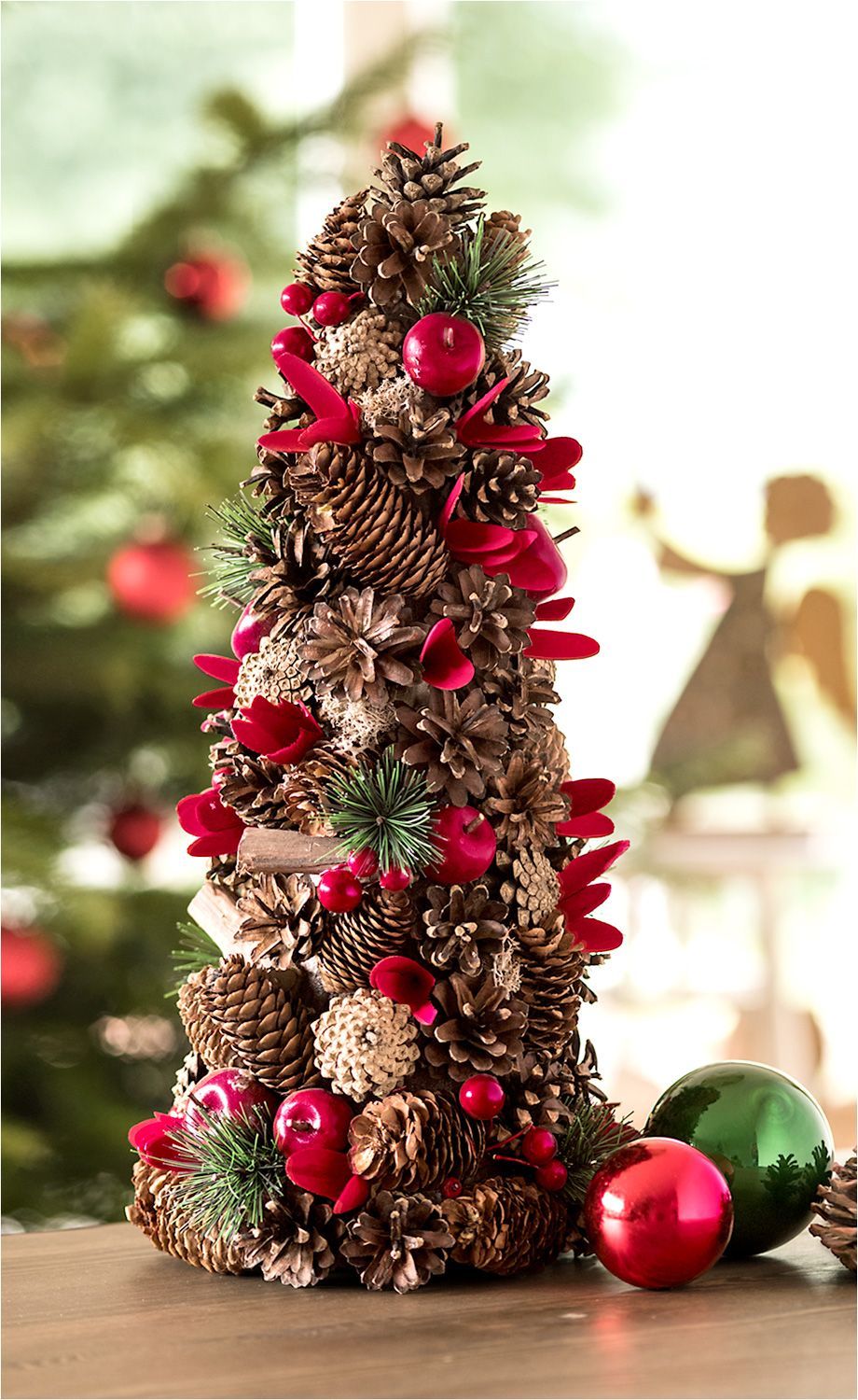 Rustic Tabletop Christmas Tree Adorned with Pinecones and Red Ornaments Rustic Tabletop Christmas Tree Adorned with Pinecones and Red Ornaments — Red and Green Christmas Tree