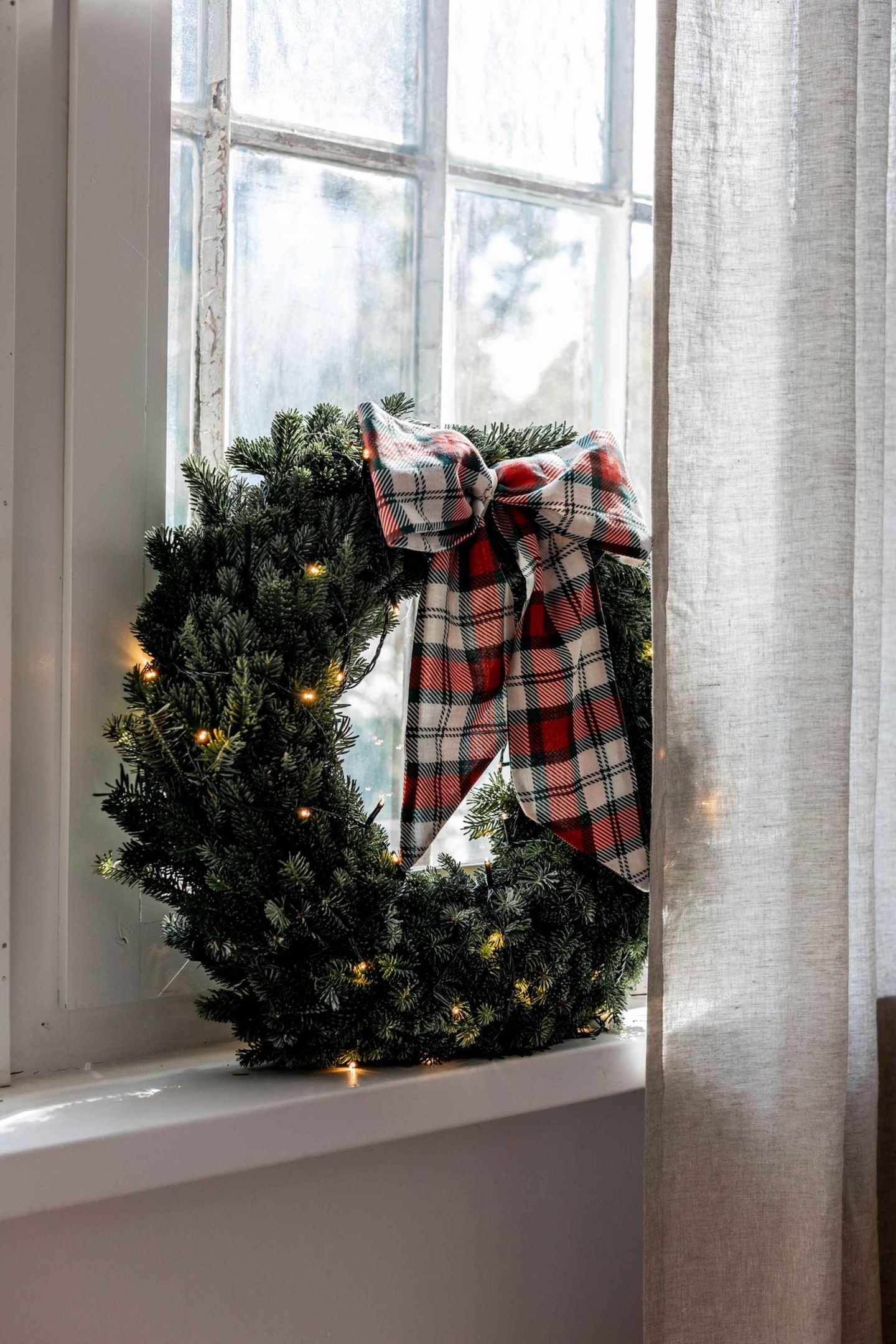 Traditional Evergreen Wreath with Plaid Bow and Fairy Lights Traditional Evergreen Wreath with Plaid Bow and Fairy Lights — Christmas Window Wreaths