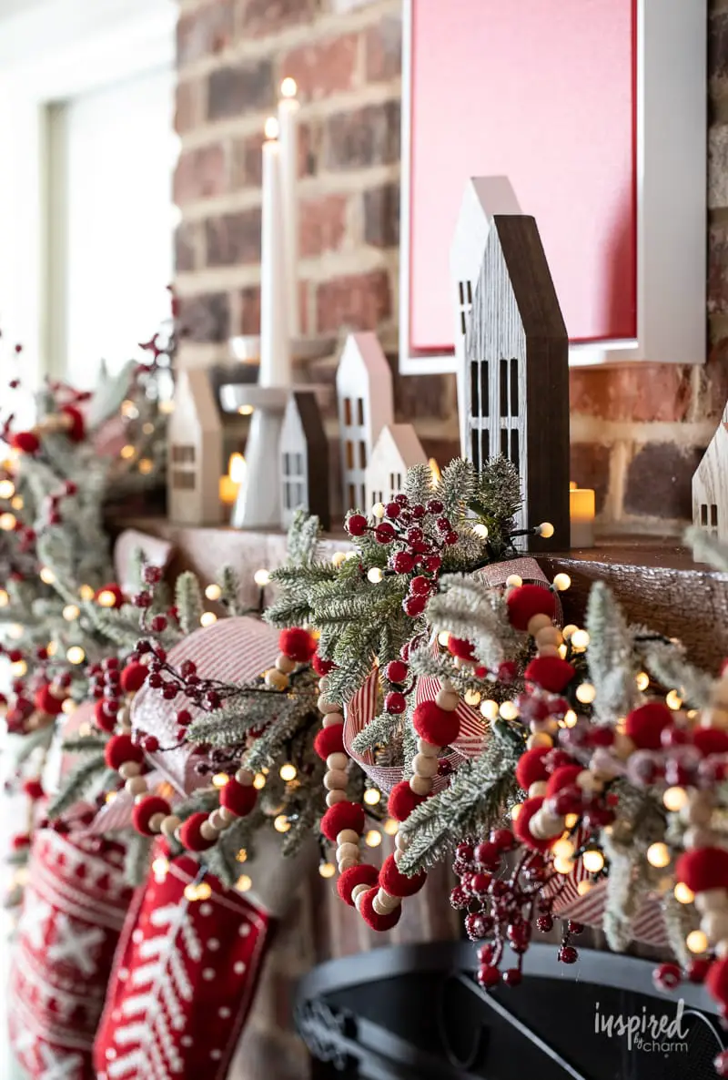Whimsical Mantelpiece with Wooden Houses and Berry Garland — Whimsical Christmas Decor