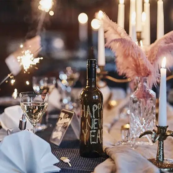 Atmospheric Table Detail with 'Happy New Year' Bottle and Sparkler Atmospheric Table Detail with 'Happy New Year' Bottle and Sparkler — New Years Eve Party Decor