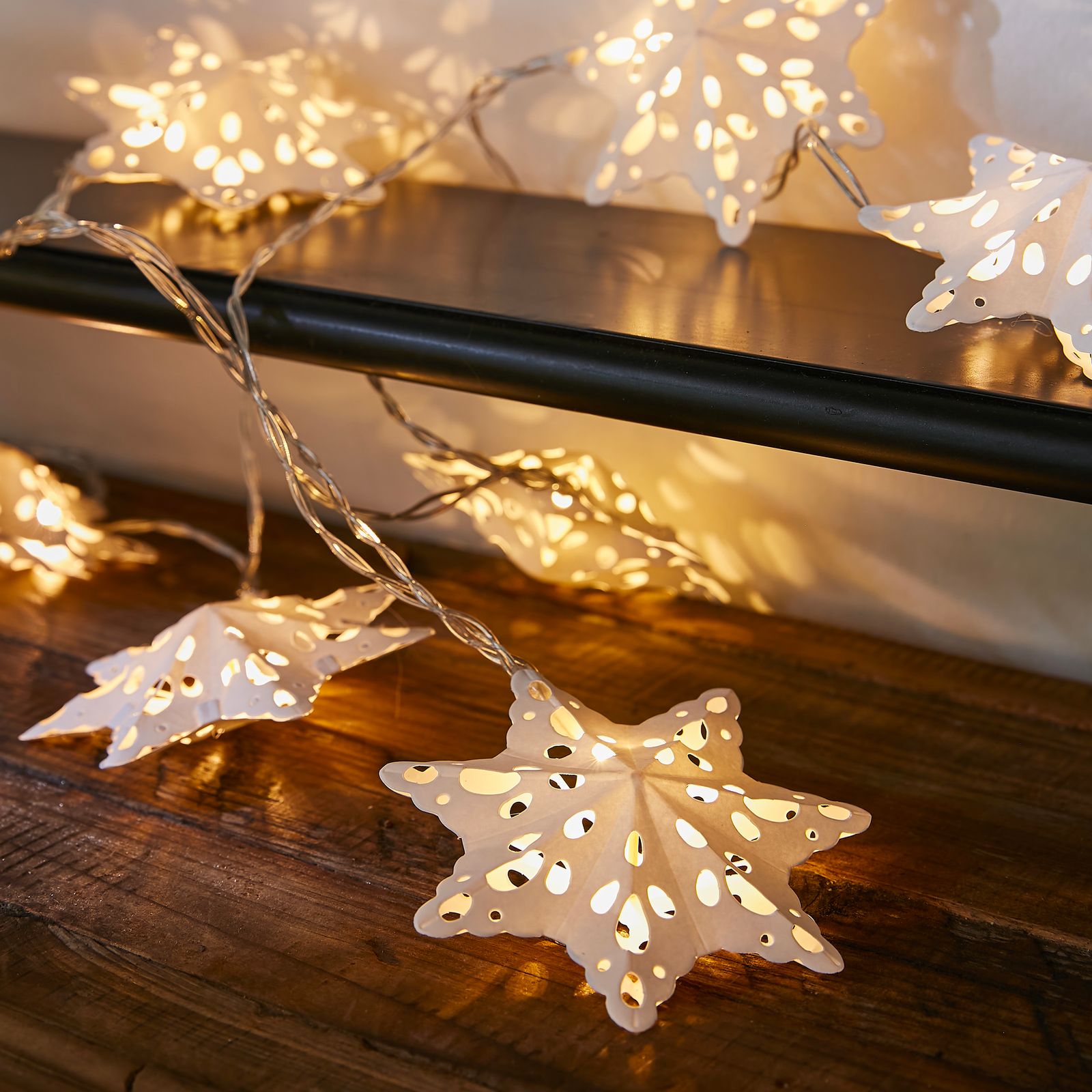 Illuminated Paper Star Lanterns on a Shelf — Paper Snowflakes