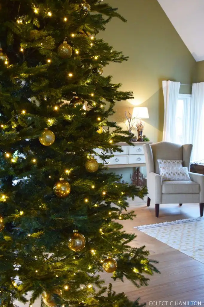 Close-Up on a Christmas Tree Laden with Golden Ornaments and Fairy Lights Close-Up on a Christmas Tree Laden with Golden Ornaments and Fairy Lights — Christmas Fairy Lights Living Room