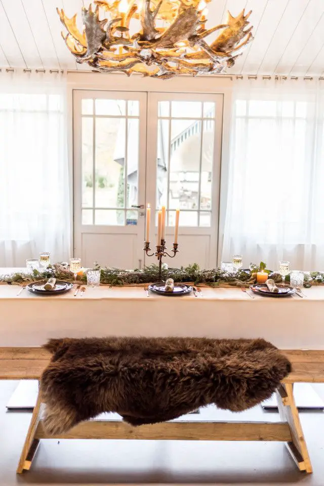Rustic Lodge Coziness: Sheepskin Throws on Bench Seating — Christmas Wedding Decor