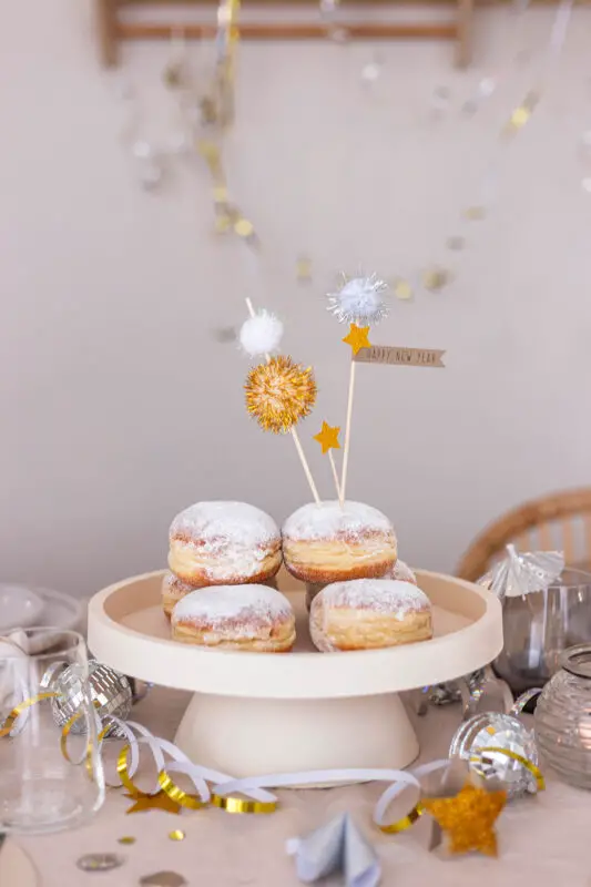 Festive Donut Centerpiece with Gold and Silver Pom-Pom Toppers Festive Donut Centerpiece with Gold and Silver Pom-Pom Toppers — New Years Eve Table Decor