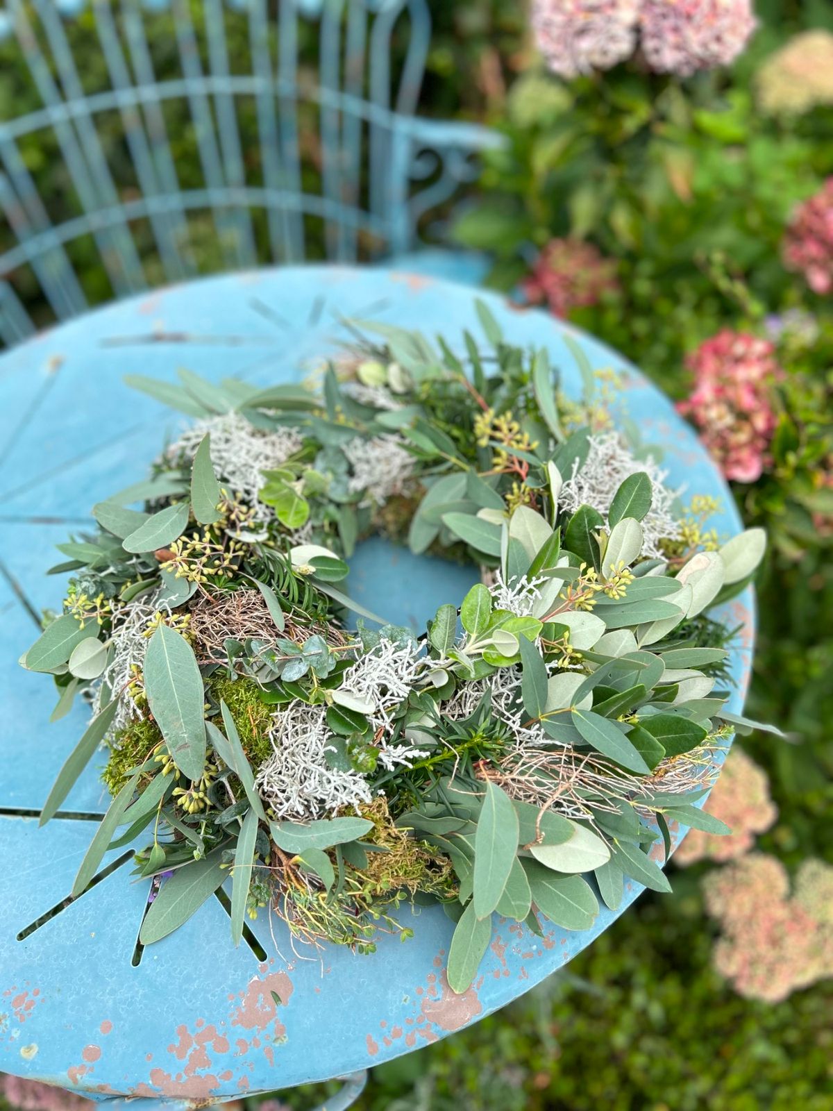 Mixed Greenery Wreath on a Blue Metal Table Mixed Greenery Wreath on a Blue Metal Table — DIY Christmas Wreath