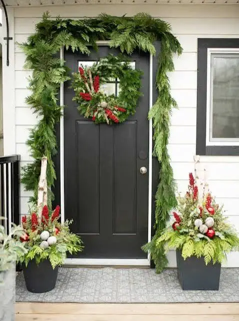 Dramatic Black Door with Abundant Evergreen Garland — Winter Front Door Decor