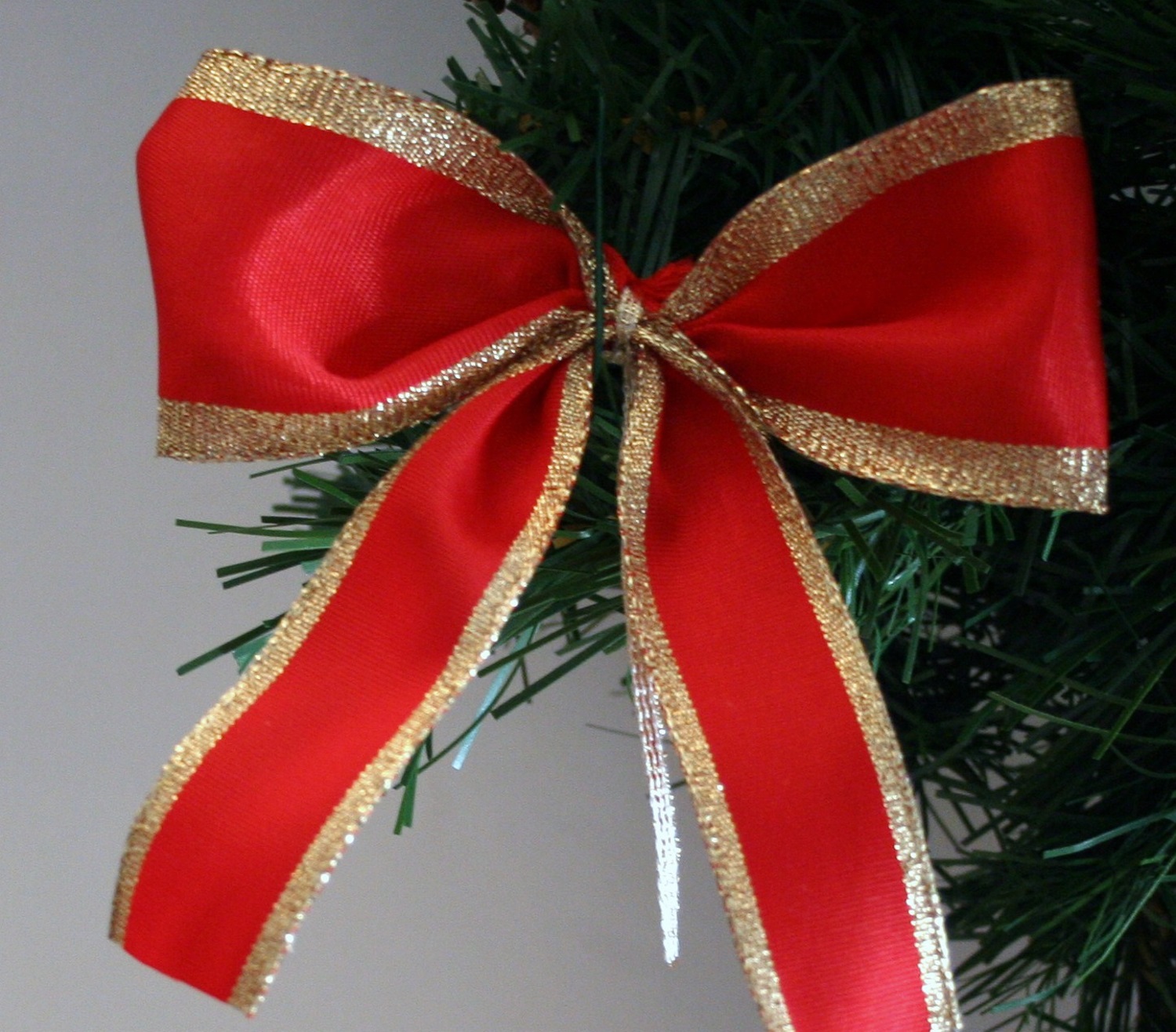 Vibrant Red Ribbon Bow with Sparkling Gold Trim on Christmas Tree Vibrant Red Ribbon Bow with Sparkling Gold Trim on Christmas Tree — Red and Gold Christmas Tree