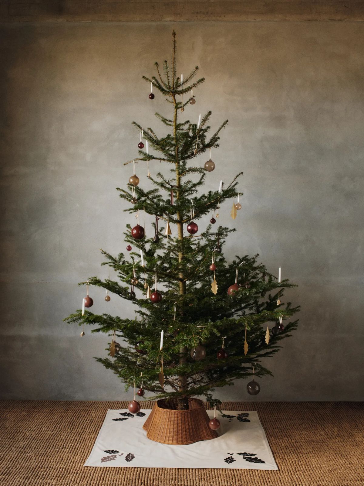 Minimalist Christmas Tree with Burgundy Baubles and Wicker Collar — Christmas Tree Trends 2026